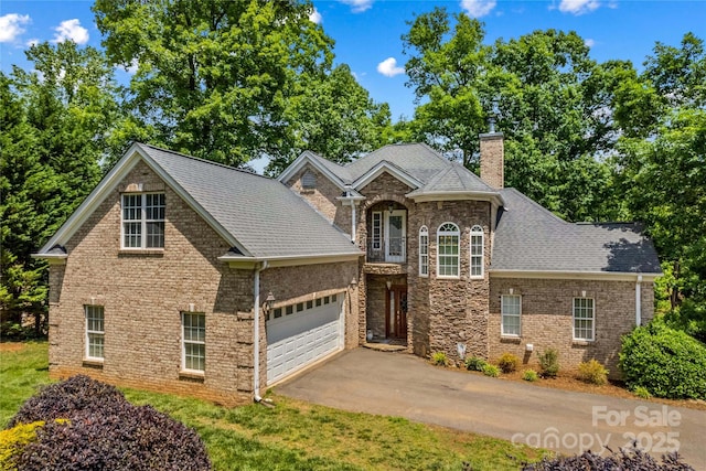 141 Ridge Top Rd, Mooresville, NC 28117 - view of front facade with a chimney, an attached garage, asphalt driveway, roof with shingles, and brick siding