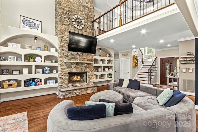 141 Ridge Top Rd, Mooresville, NC 28117 - living area featuring ornamental molding, stairs, wood finished floors, a stone fireplace, and a towering ceiling