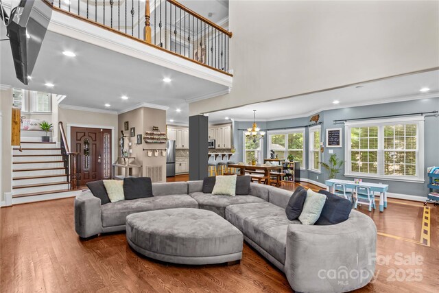 141 Ridge Top Rd, Mooresville, NC 28117 - living area featuring crown molding, wood finished floors, stairway, a chandelier, and recessed lighting