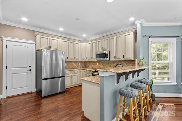 141 Ridge Top Rd, Mooresville, NC 28117 - kitchen with stainless steel appliances, cream cabinetry, a peninsula, ornamental molding, and recessed lighting