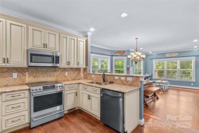141 Ridge Top Rd, Mooresville, NC 28117 - kitchen with cream cabinets, appliances with stainless steel finishes, a sink, a peninsula, and plenty of natural light