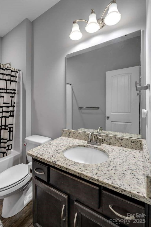 bathroom with vanity, toilet, wood finished floors, and shower / bathtub combination with curtain
