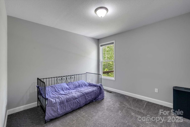 bedroom featuring baseboards, a textured ceiling, and carpet
