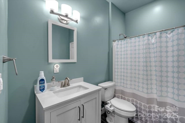 bathroom featuring vanity, toilet, and curtained shower