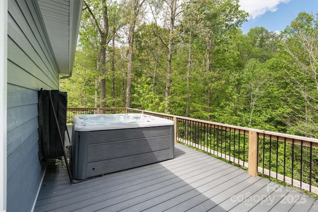 deck with a hot tub and a forest view