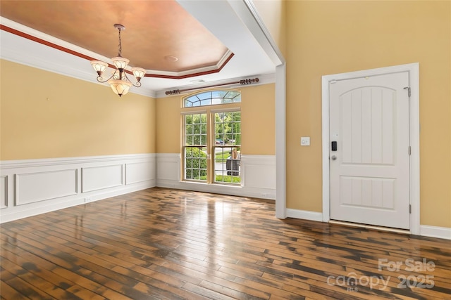2346 Donnington Ln NW, Concord, NC 28027 - entryway with a raised ceiling, a chandelier, wood-type flooring, a wainscoted wall, and crown molding