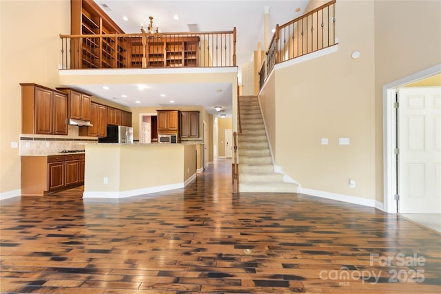 2346 Donnington Ln NW, Concord, NC 28027 - unfurnished living room featuring dark wood-style flooring, stairway, a towering ceiling, baseboards, and recessed lighting