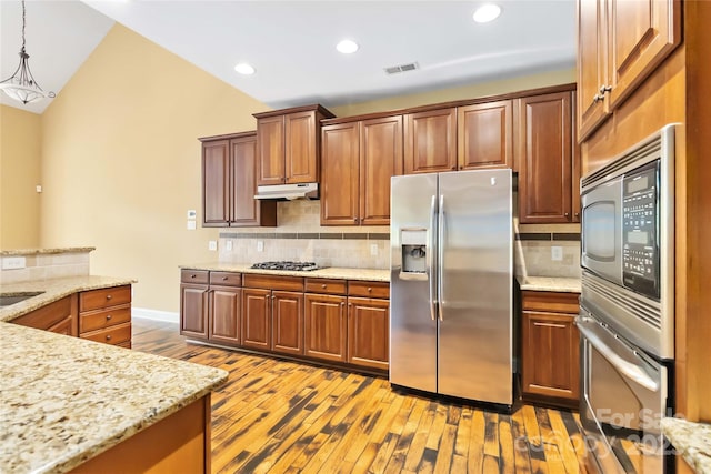 2346 Donnington Ln NW, Concord, NC 28027 - kitchen with stainless steel appliances, under cabinet range hood, light wood-style floors, backsplash, and recessed lighting