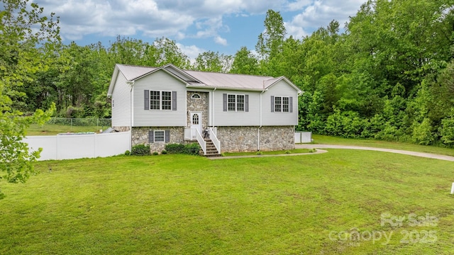 raised ranch with stone siding and metal roof
