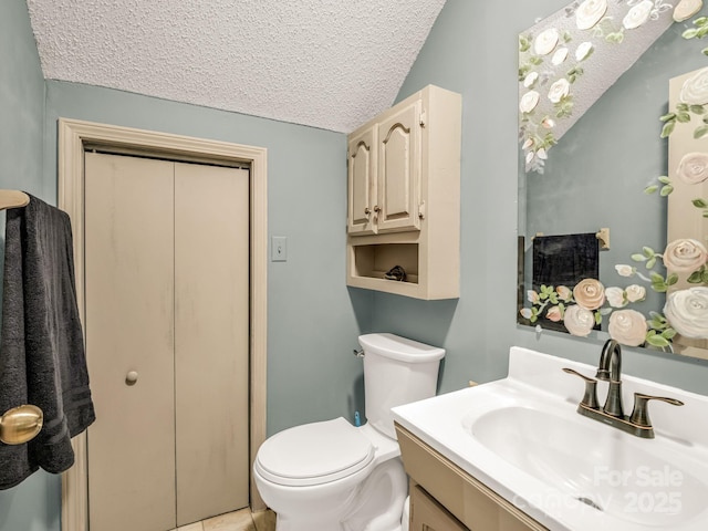 bathroom with toilet, a textured ceiling, and vanity