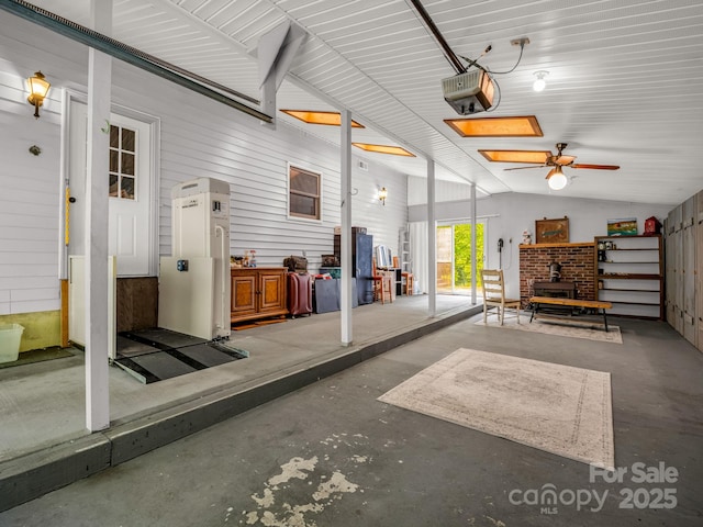 garage with a garage door opener, a wood stove, and ceiling fan