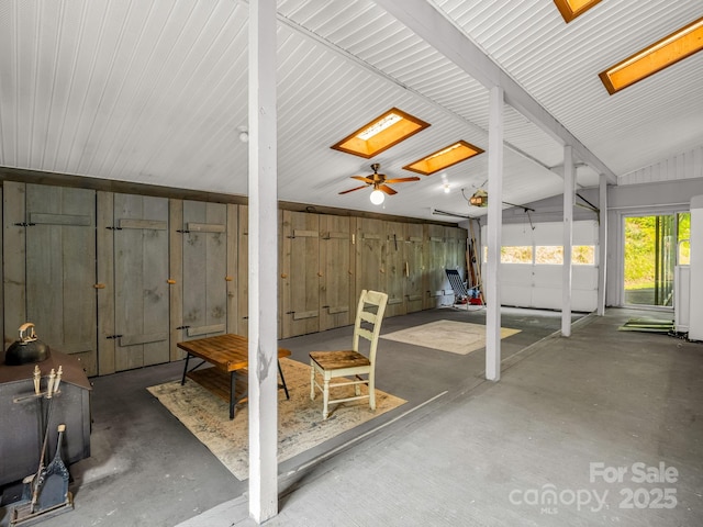 interior space featuring a skylight, concrete flooring, and lofted ceiling