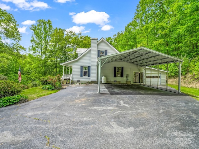 view of front of property with a chimney and driveway