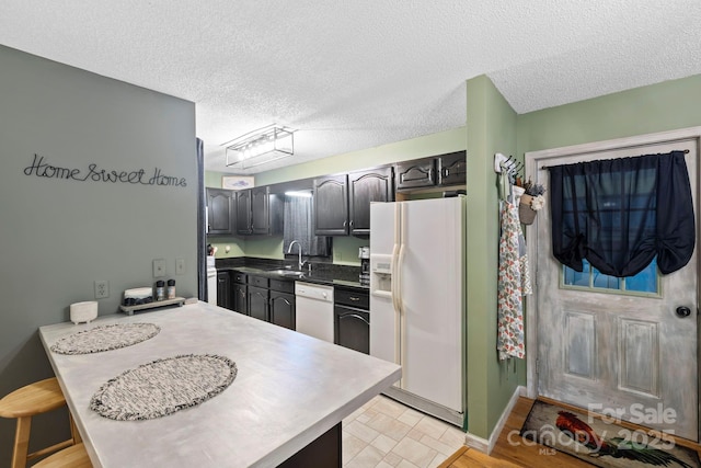 10 Kettle Creek Ln, Brevard, NC 28712 - kitchen with white appliances, a textured ceiling, a sink, a peninsula, and baseboards