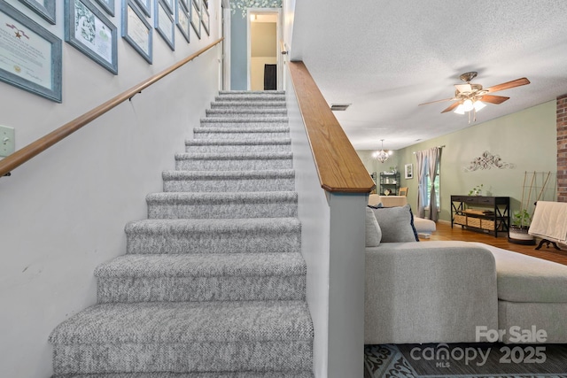 10 Kettle Creek Ln, Brevard, NC 28712 - staircase with a ceiling fan, a textured ceiling, wood finished floors, and a chandelier