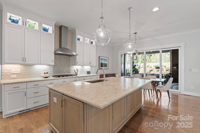 1502 Matthew Mcclure Cir, Davidson, NC 28036 - kitchen featuring wall chimney range hood, a sink, stainless steel gas stovetop, a kitchen island with sink, and decorative backsplash