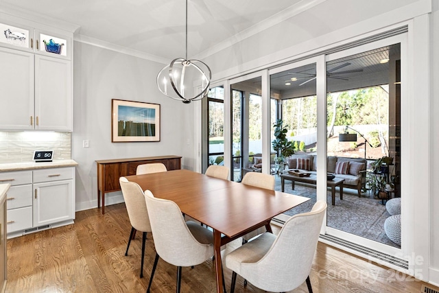 1502 Matthew Mcclure Cir, Davidson, NC 28036 - dining space with ornamental molding, light wood-style flooring, a chandelier, and baseboards