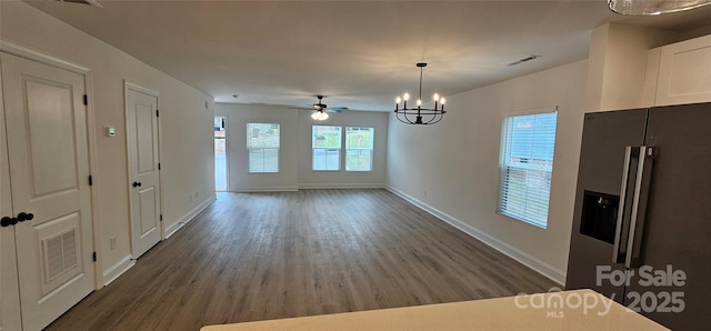 unfurnished dining area featuring wood finished floors, baseboards, a chandelier, and ceiling fan