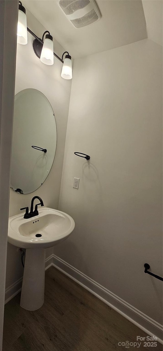 bathroom with wood finished floors, baseboards, and a sink