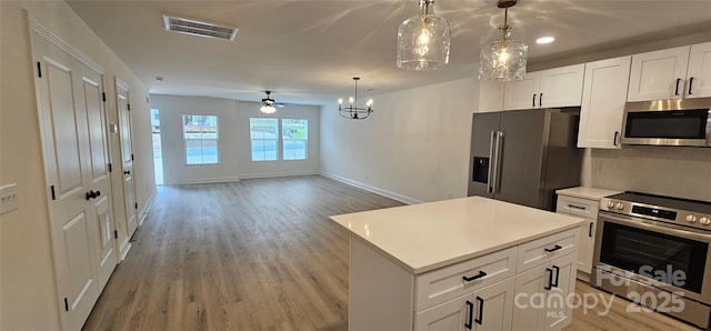 kitchen with appliances with stainless steel finishes, light wood-style flooring, light countertops, and baseboards
