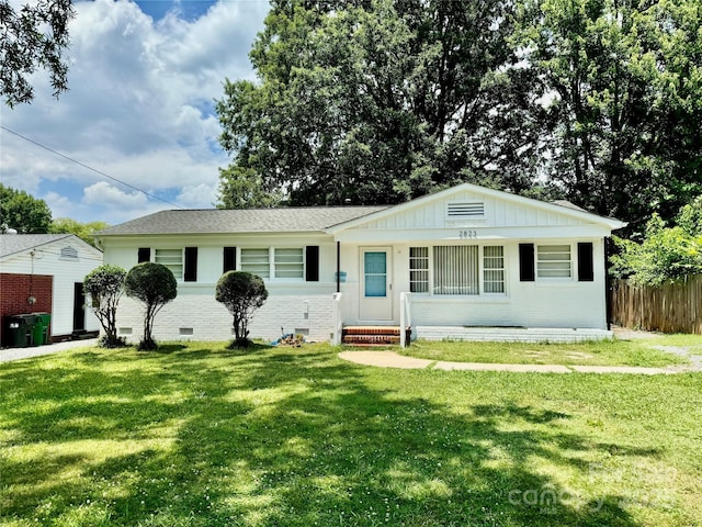 ranch-style home with board and batten siding, brick siding, entry steps, and a shingled roof