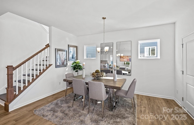dining area with stairway, wood finished floors, a chandelier, and baseboards