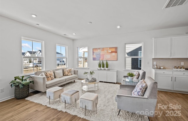 living area featuring light wood finished floors, recessed lighting, and baseboards