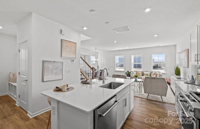 kitchen with a sink, stainless steel appliances, dark wood-style floors, plenty of natural light, and recessed lighting