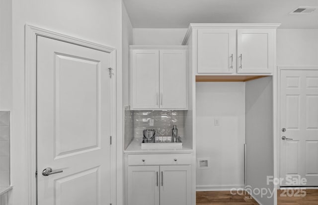 kitchen featuring white cabinets, tasteful backsplash, and light countertops