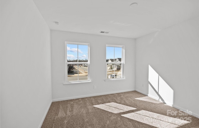 carpeted empty room featuring baseboards