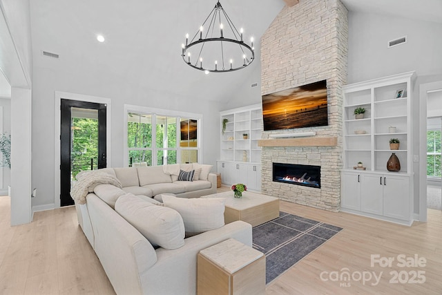 9564 Regent Dr, Davidson, NC 28036 - living room featuring a stone fireplace, high vaulted ceiling, wood finished floors, a chandelier, and recessed lighting