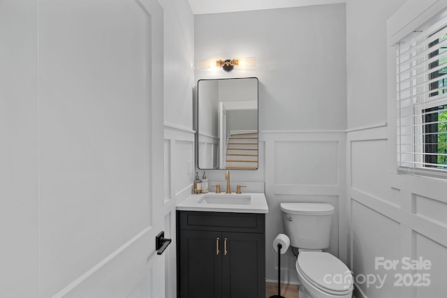 9564 Regent Dr, Davidson, NC 28036 - half bath featuring a decorative wall, vanity, toilet, and wainscoting