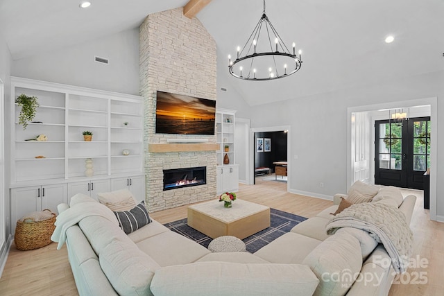 9564 Regent Dr, Davidson, NC 28036 - living room with a chandelier, high vaulted ceiling, a stone fireplace, light wood-style flooring, and recessed lighting