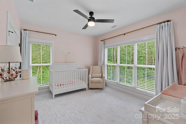 9564 Regent Dr, Davidson, NC 28036 - bedroom with multiple windows, ceiling fan, a nursery area, and light carpet