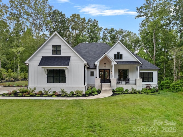 9564 Regent Dr, Davidson, NC 28036 - modern inspired farmhouse featuring board and batten siding, french doors, a front lawn, and covered porch