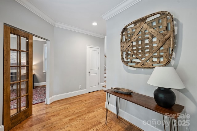 hallway featuring crown molding, light wood finished floors, baseboards, and recessed lighting