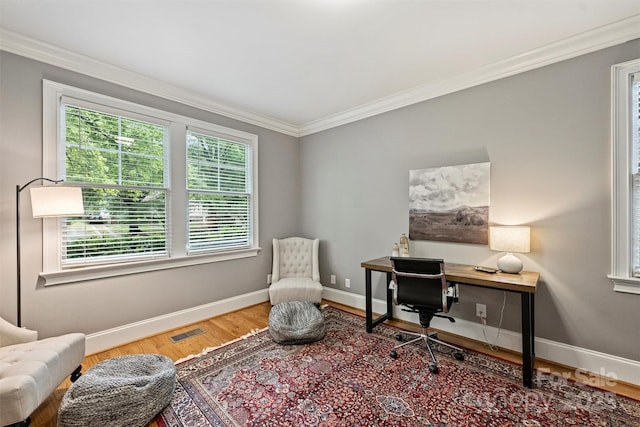 home office featuring plenty of natural light, crown molding, wood finished floors, and baseboards