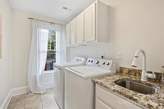 laundry room featuring separate washer and dryer, cabinet space, baseboards, and light tile patterned flooring