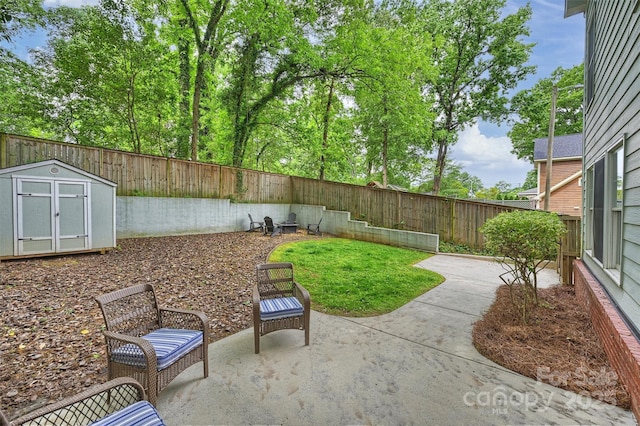 fenced backyard featuring a storage shed, a patio area, and an outbuilding