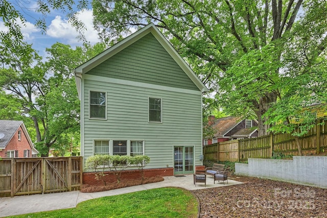 back of property featuring a patio area, a fenced backyard, and a gate