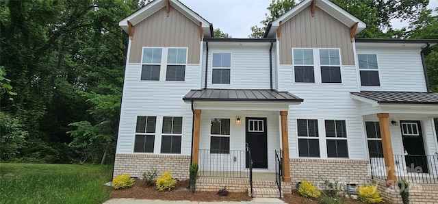 view of front facade featuring a standing seam roof, board and batten siding, and covered porch