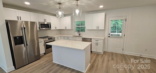 kitchen featuring stainless steel appliances, a sink, light wood-type flooring, white cabinets, and recessed lighting