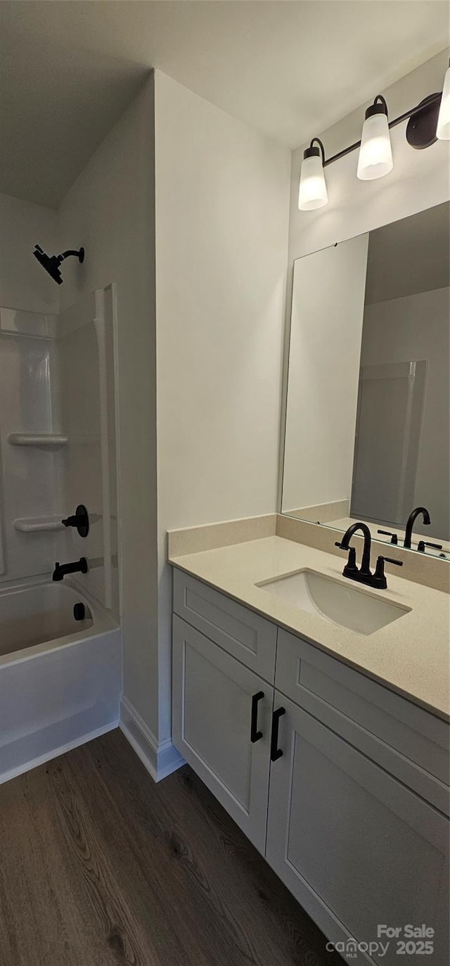 bathroom with wood finished floors, vanity, and shower / tub combination
