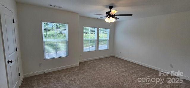 carpeted spare room with ceiling fan and baseboards