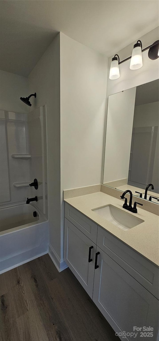full bathroom with wood finished floors, vanity, and shower / bathtub combination