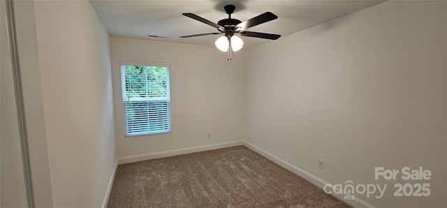 spare room with dark carpet, baseboards, and a ceiling fan