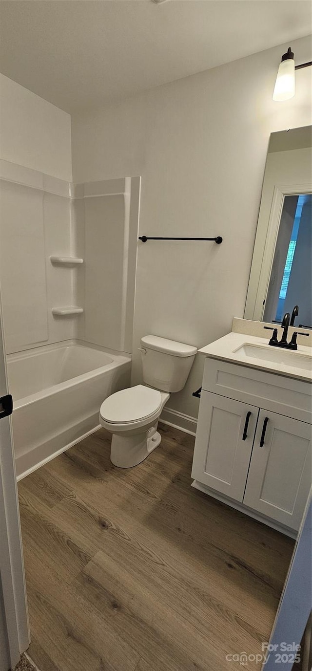 full bath with wood finished floors, toilet, vanity, and shower / bathtub combination