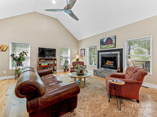 1846 Utah Mountain Rd, Waynesville, NC 28785 - living area featuring wood finished floors, ceiling fan, baseboards, a fireplace with raised hearth, and high vaulted ceiling