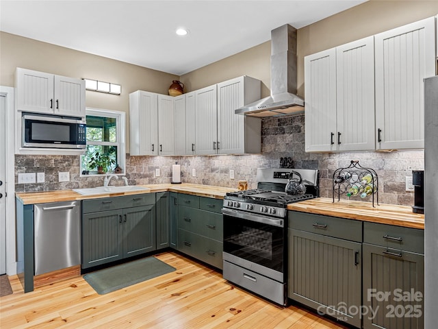 1846 Utah Mountain Rd, Waynesville, NC 28785 - kitchen featuring stainless steel appliances, butcher block counters, wall chimney exhaust hood, a sink, and recessed lighting