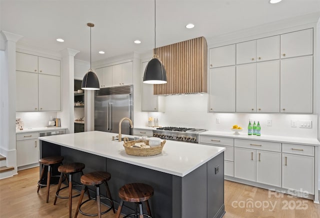 922 Everett Pl, Charlotte, NC 28205 - kitchen featuring stainless steel built in fridge, wall chimney range hood, stove, light wood-style flooring, and a sink